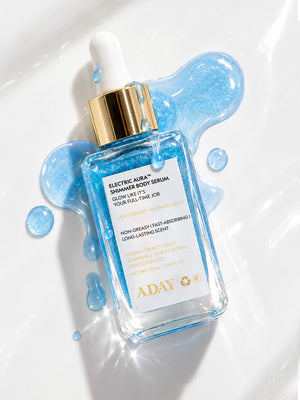 ADAY Electric Aura Shimmer Body Serum lying in a pool of blue shimmer serum