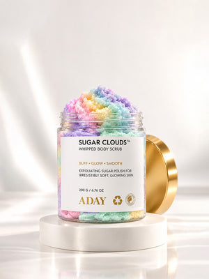 ADAY Sugar Clouds Whipped Body Scrub open on a white pedestal, showing the swirled sugar polish