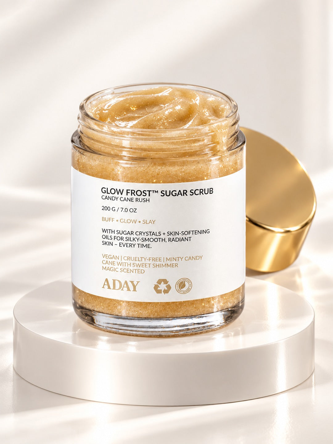 Scrub Trio: ADAY Glow Frost Sugar Scrub in Candy Cane Rush, a 200 g glass jar with a gold lid