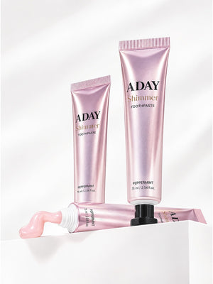 Two tubes of ADAY Pink Shimmer Toothpaste on white plinths, one with a curl of paste