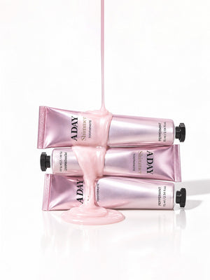 Three tubes of ADAY Pink Shimmer Toothpaste stacked with paste pouring over them