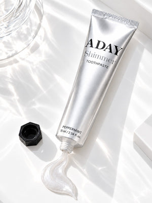 ADAY Silver Shimmer Toothpaste lying open with a curl of paste beside it