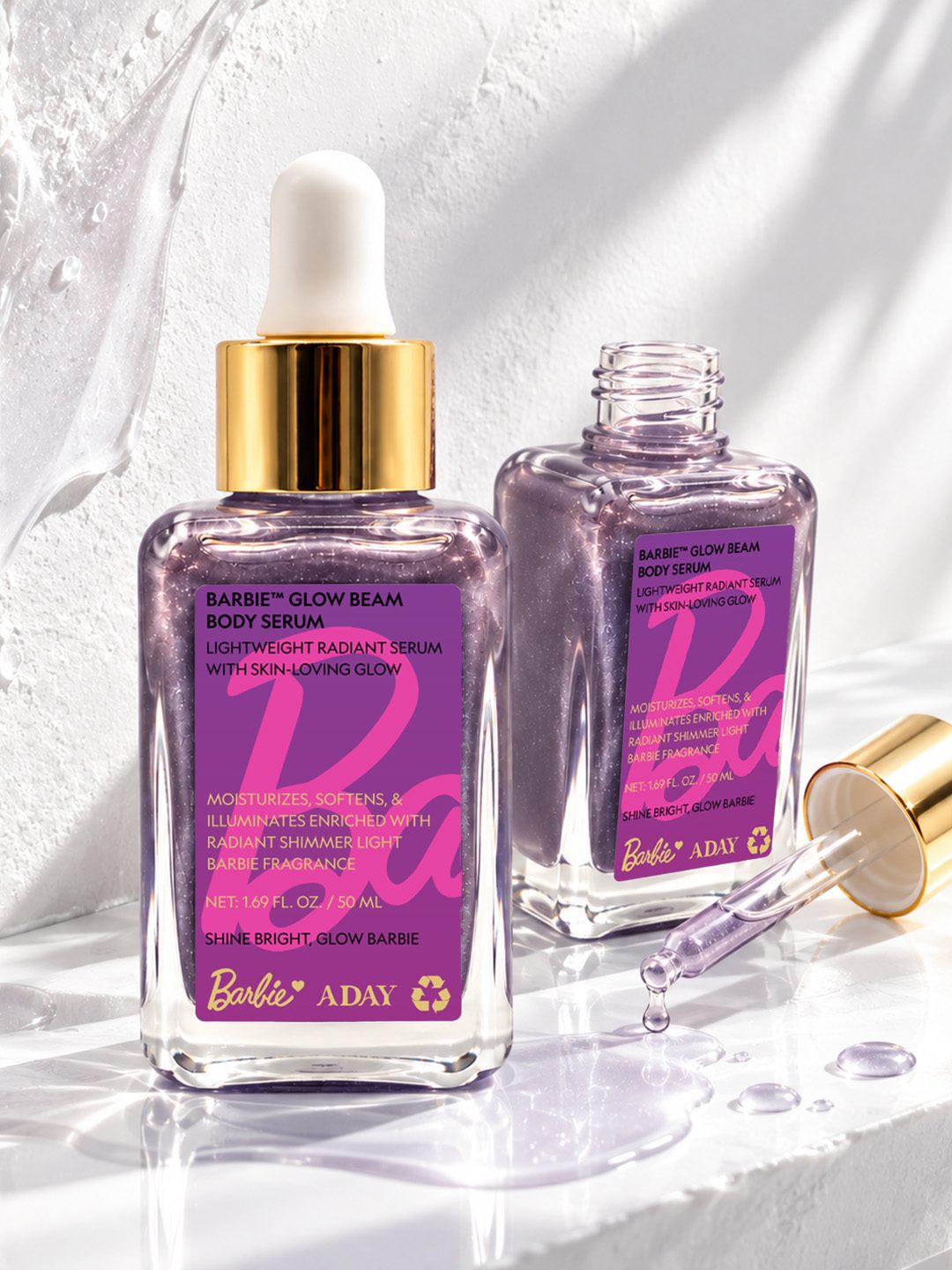 Two bottles of ADAY x Barbie Glow Beam Body Serum with the dropper alongside