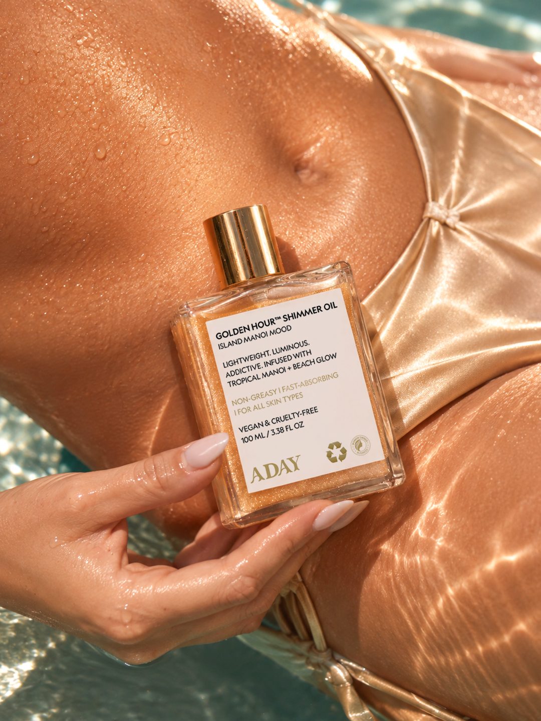 A model in a pool holding the ADAY Golden Hour Shimmer Oil